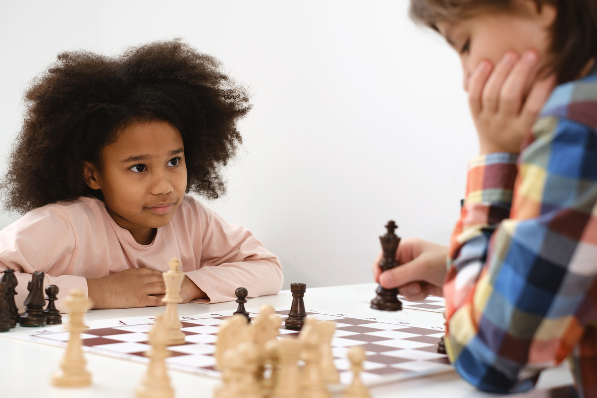 Multiethnic Kids Playing Chess Board Game at School